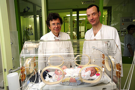 Prof. Roos, langjähriger Chefarzt der Kinderklinik Harlaching mit Dr. Gehrmann, Entwicklungsneurologe der Kinderklinik Harlaching, am Brutkasten rufen das Harl.e.kin Projekt ins Leben.